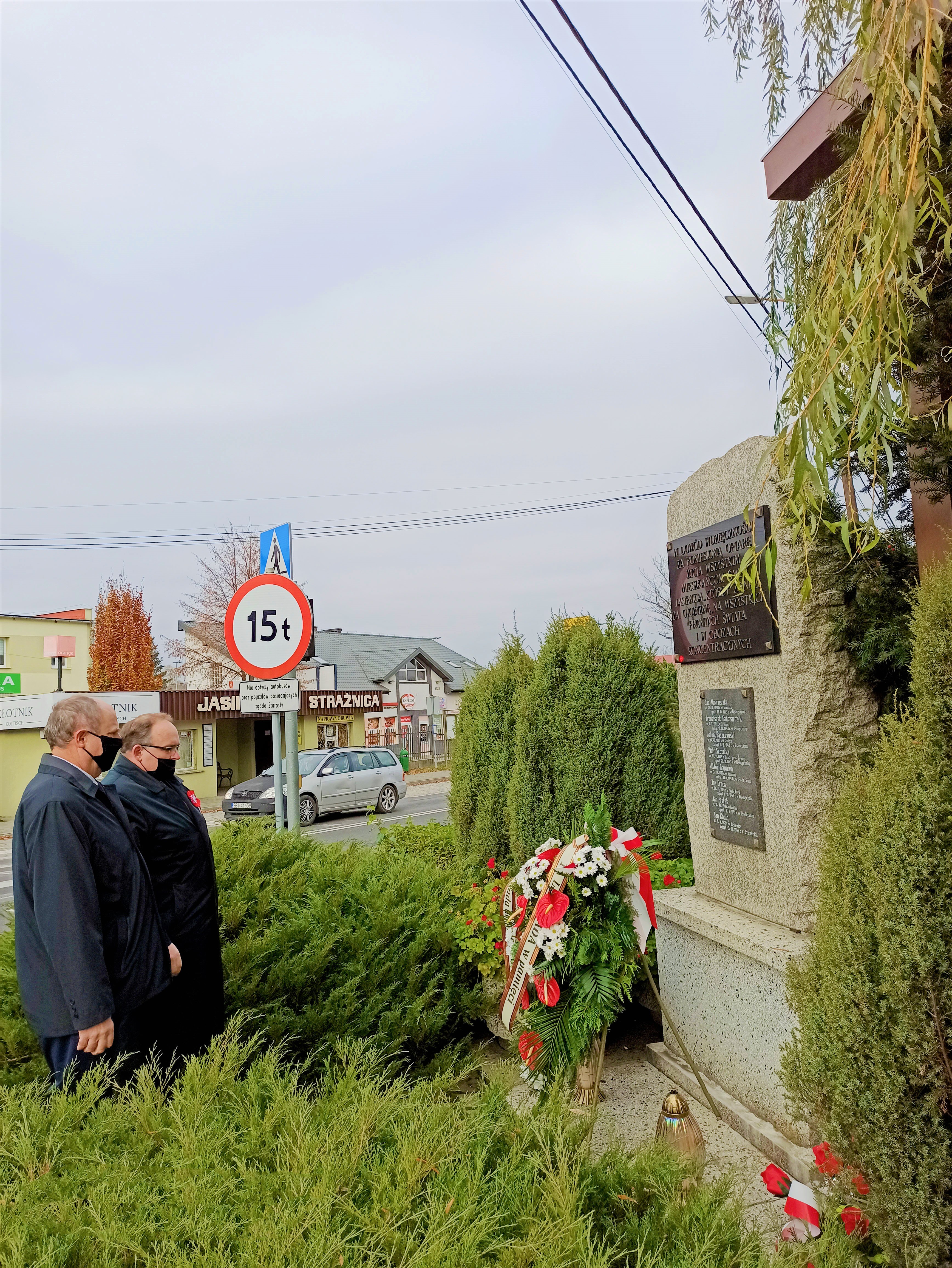 Wójt gminy Jasienica Janusz Pierzyna oraz przewodniczący Rady Gminy Czesław Machalica oddają hołd przed pomnikiem poległych w Jasienicy.