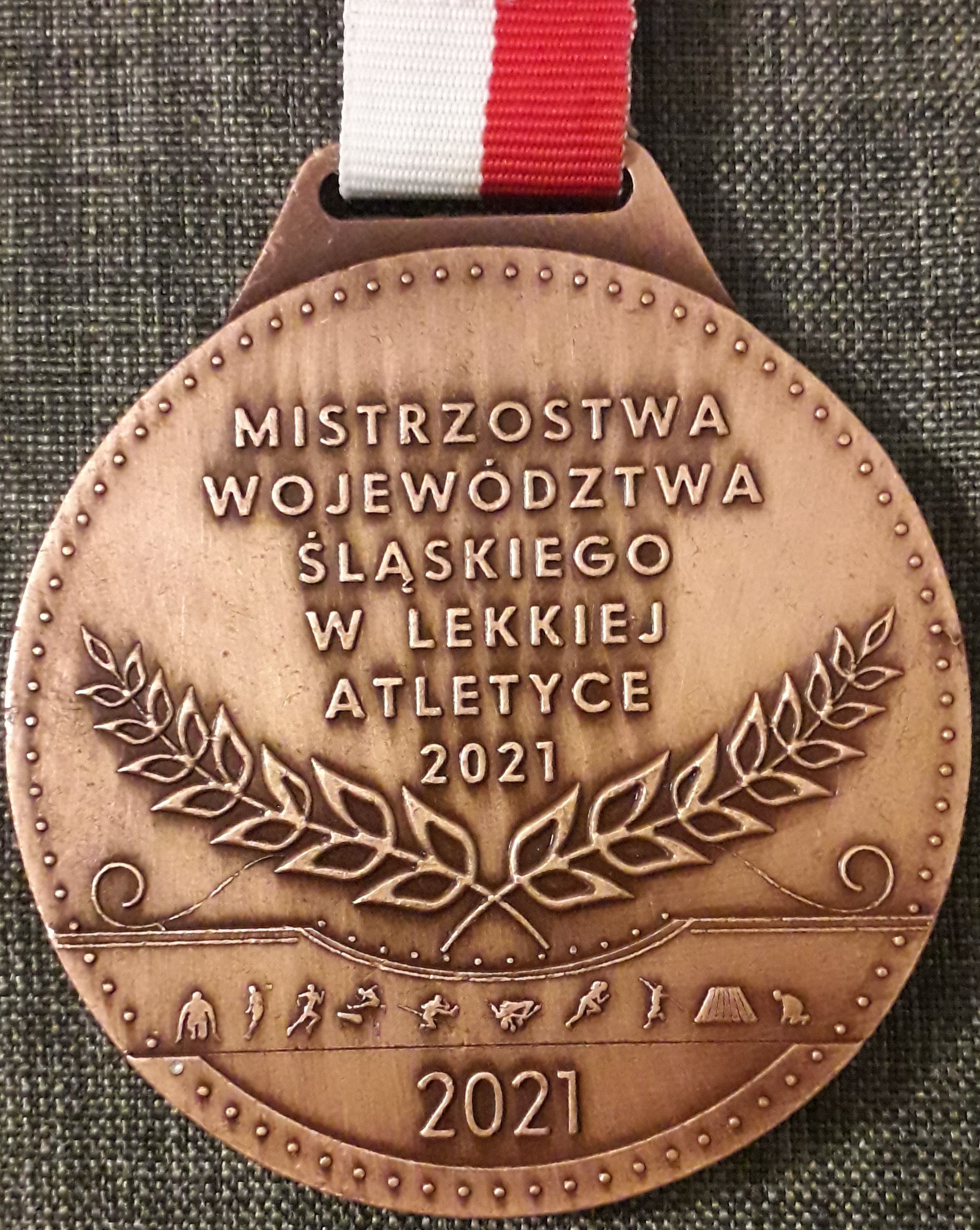 Brązowy medal z wygrawerowaną nazwą zawodów.